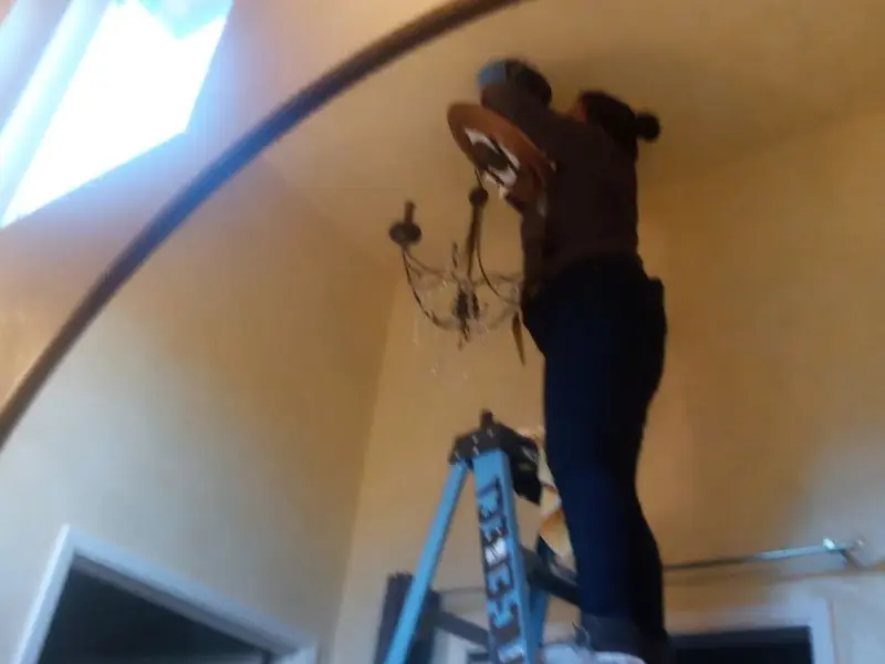 Electrician installing a chandelier in a Lemoore Station residence
